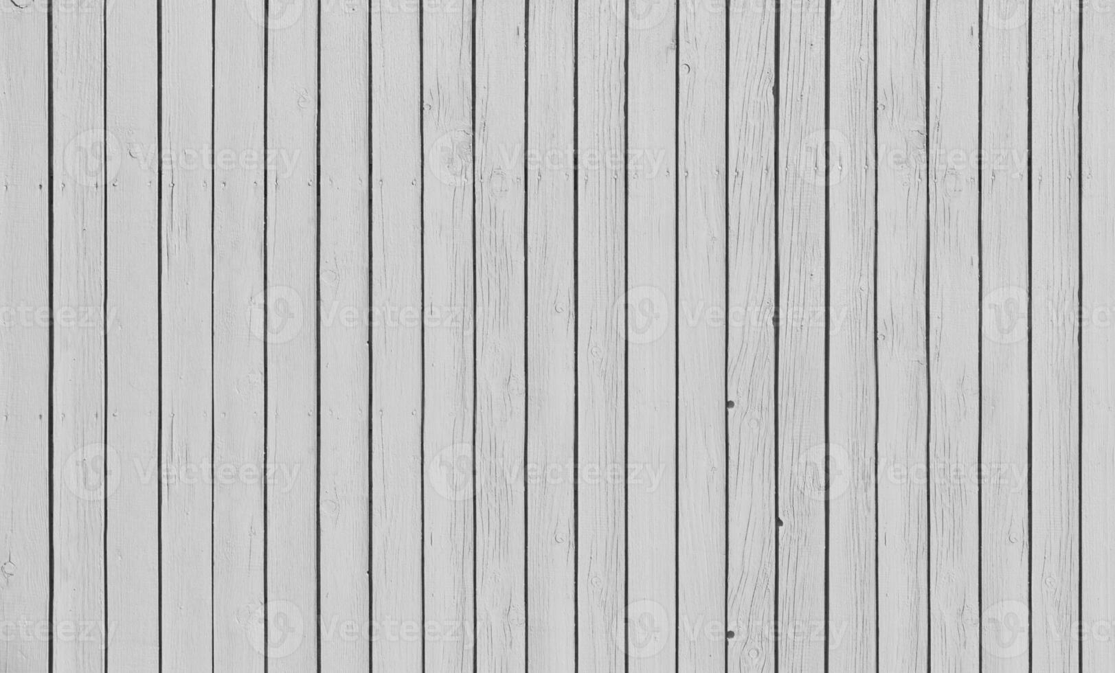 Wooden fence with parallel planks with white paint. photo