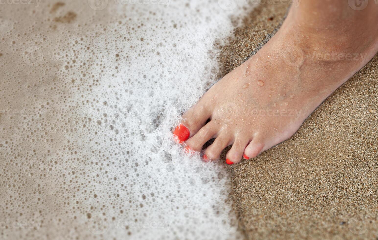 De las mujeres pies con un pedicure en el arena en el playa foto