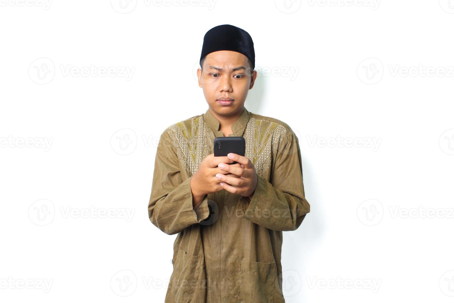 confused asian muslim man read message using smartphone show thinking expression isolated on white background photo