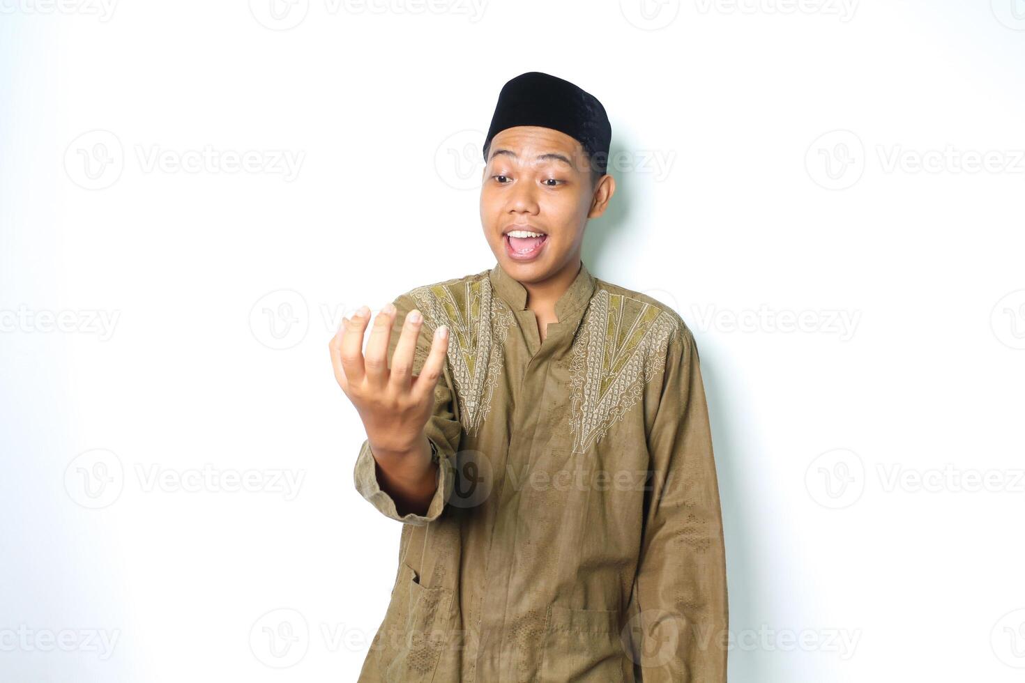 surprised asian muslim man presenting with palm like holding bowl isolated in white background photo