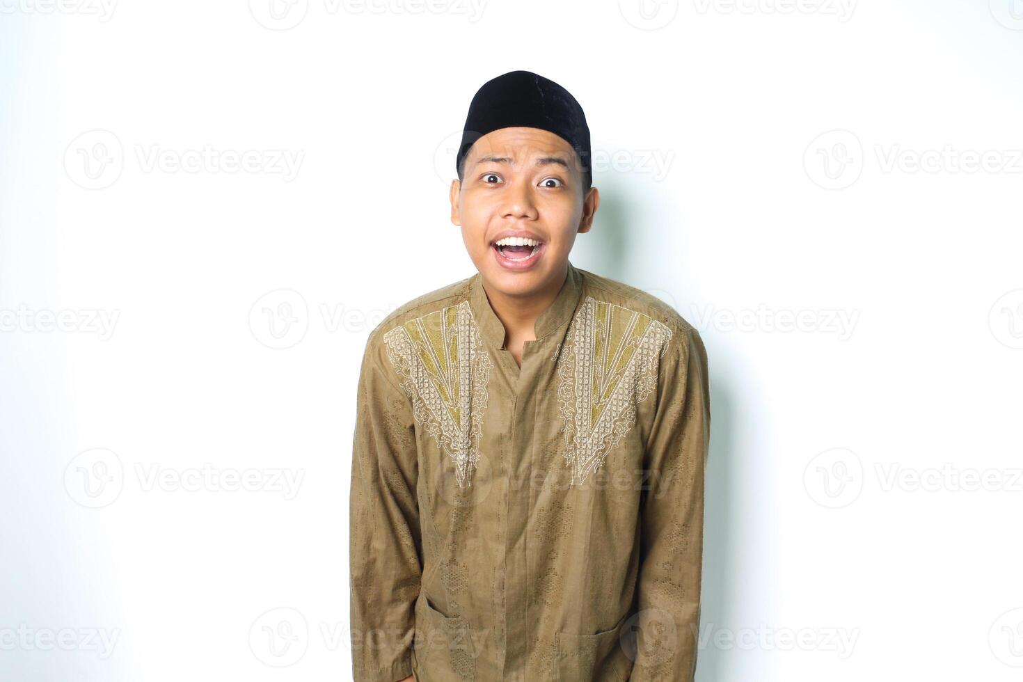 sorprendido asiático musulmán hombre vistiendo koko ropa mira aturdido aislado en blanco antecedentes foto