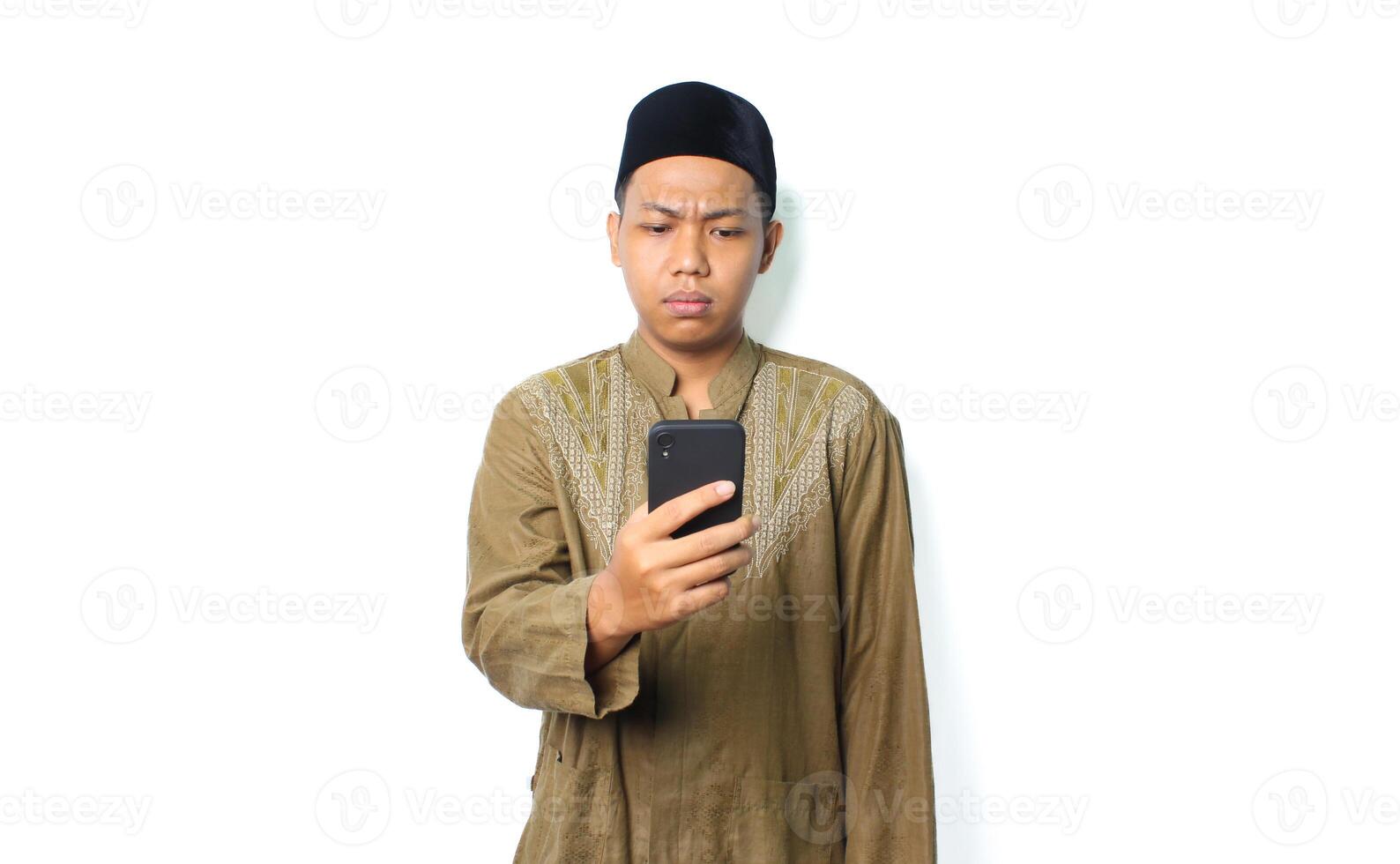 confused asian muslim man read message using smartphone show thinking expression isolated on white background photo