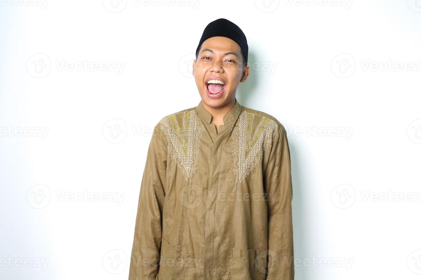 emocionado asiático musulmán hombre vistiendo islámico vestir gritando a cámara aislado en blanco antecedentes foto