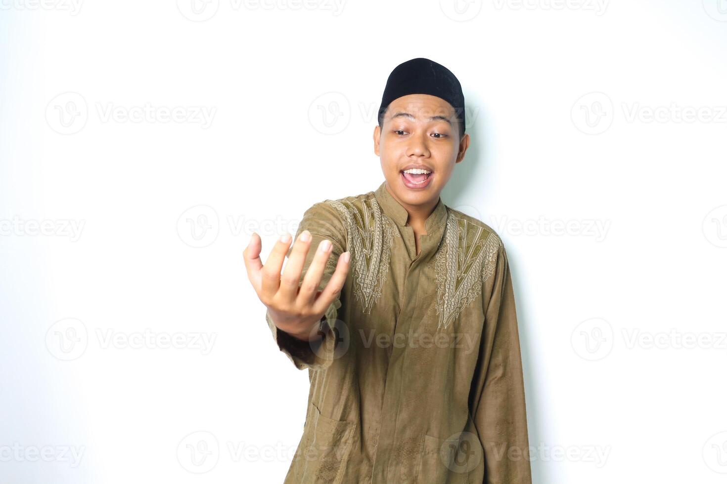 surprised asian muslim man presenting with palm like holding bowl isolated in white background photo