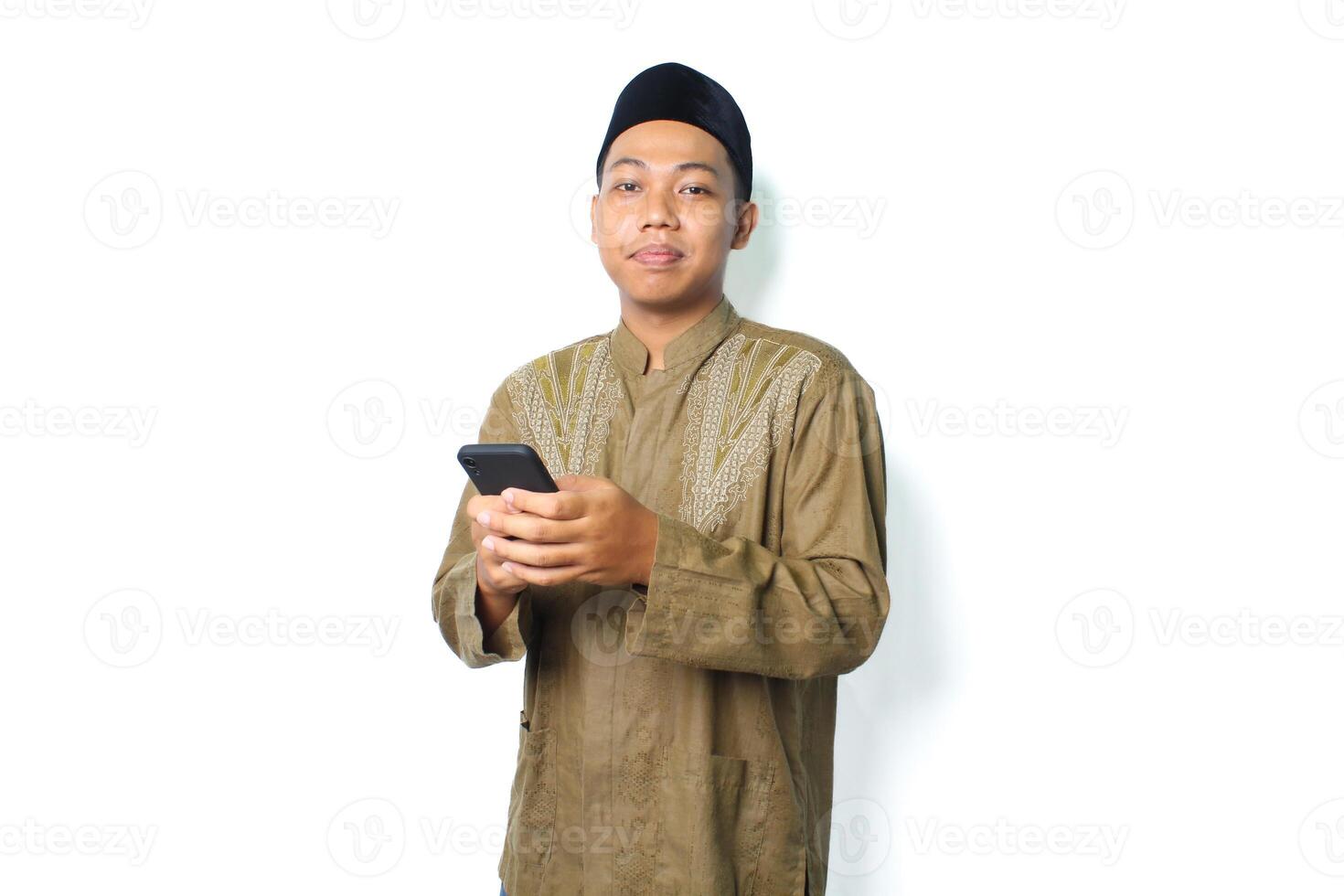 side view of pleased asian muslim man read a message using mobile phone isolated on white background photo