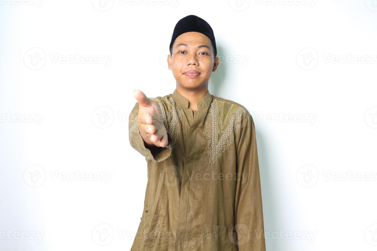 peaceful asian muslim man offering handshake at camera isolated on white background photo