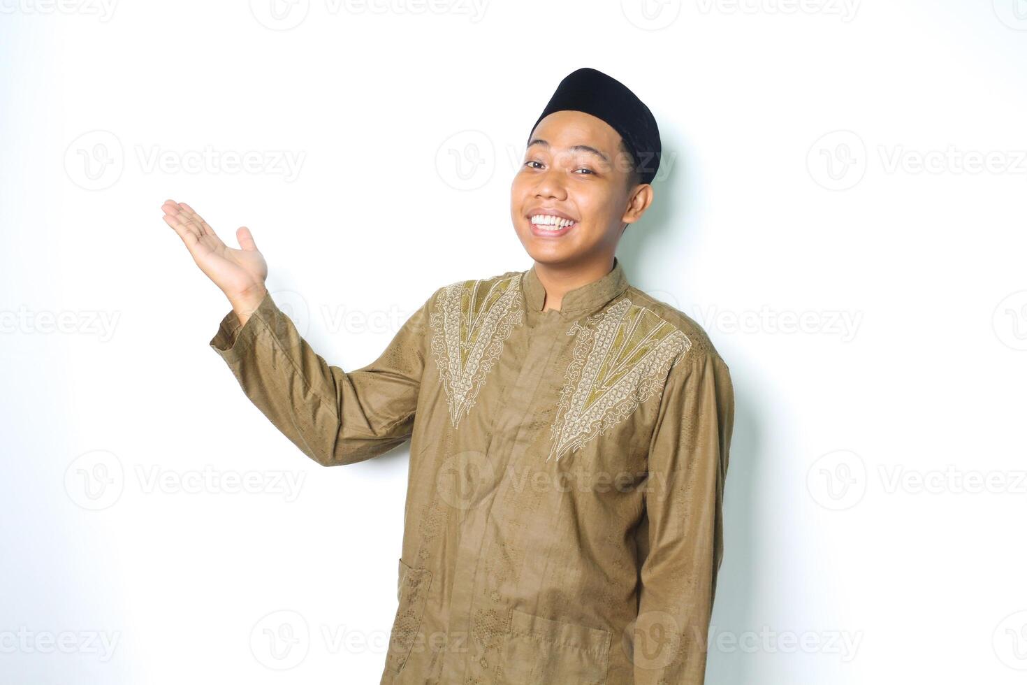 happy asian muslim man wearing koko clothes presenting to beside with open palms isolated on white background photo