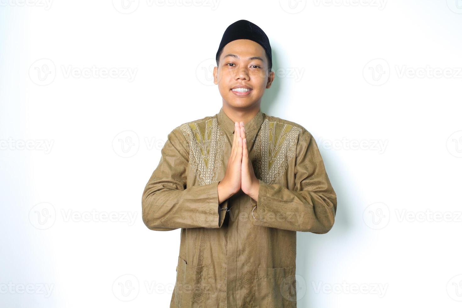 asian muslim man give greeting with smile at camera isolated on white background photo