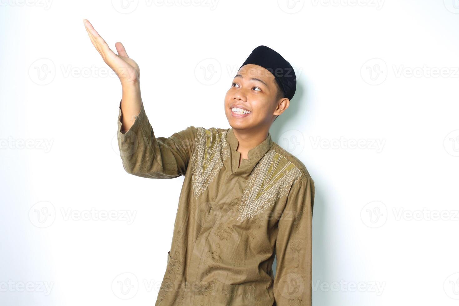 happy asian muslim man wearing koko clothes presenting to above with open palms isolated on white background photo