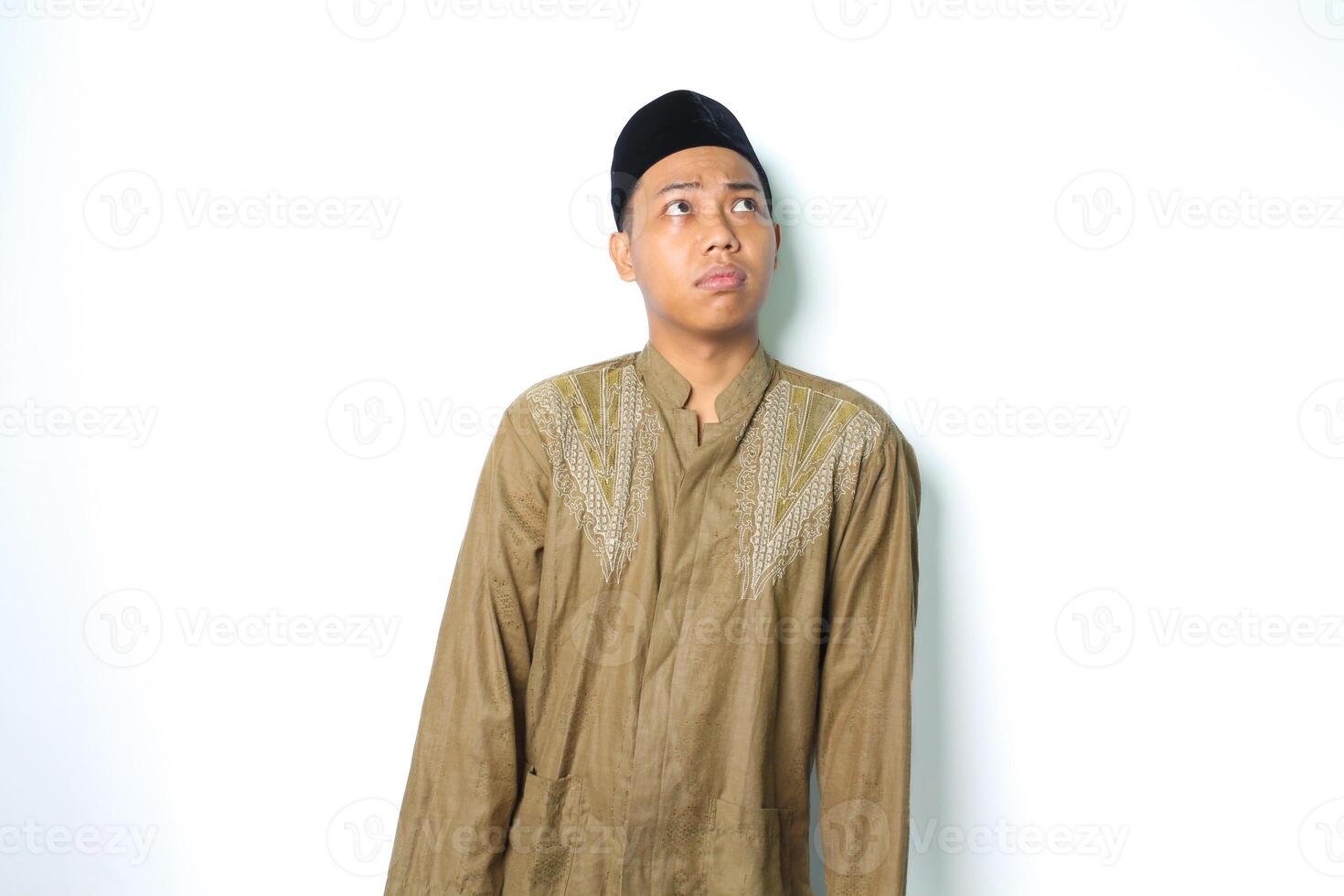 thoughtful asian muslim man wearing koko clothes confused isolated on white background photo