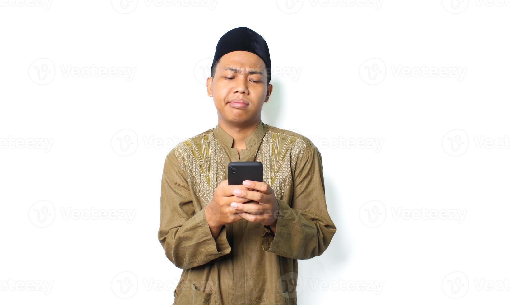 anxious asian muslim man holding mobile phone show worry expression isolated on white background photo