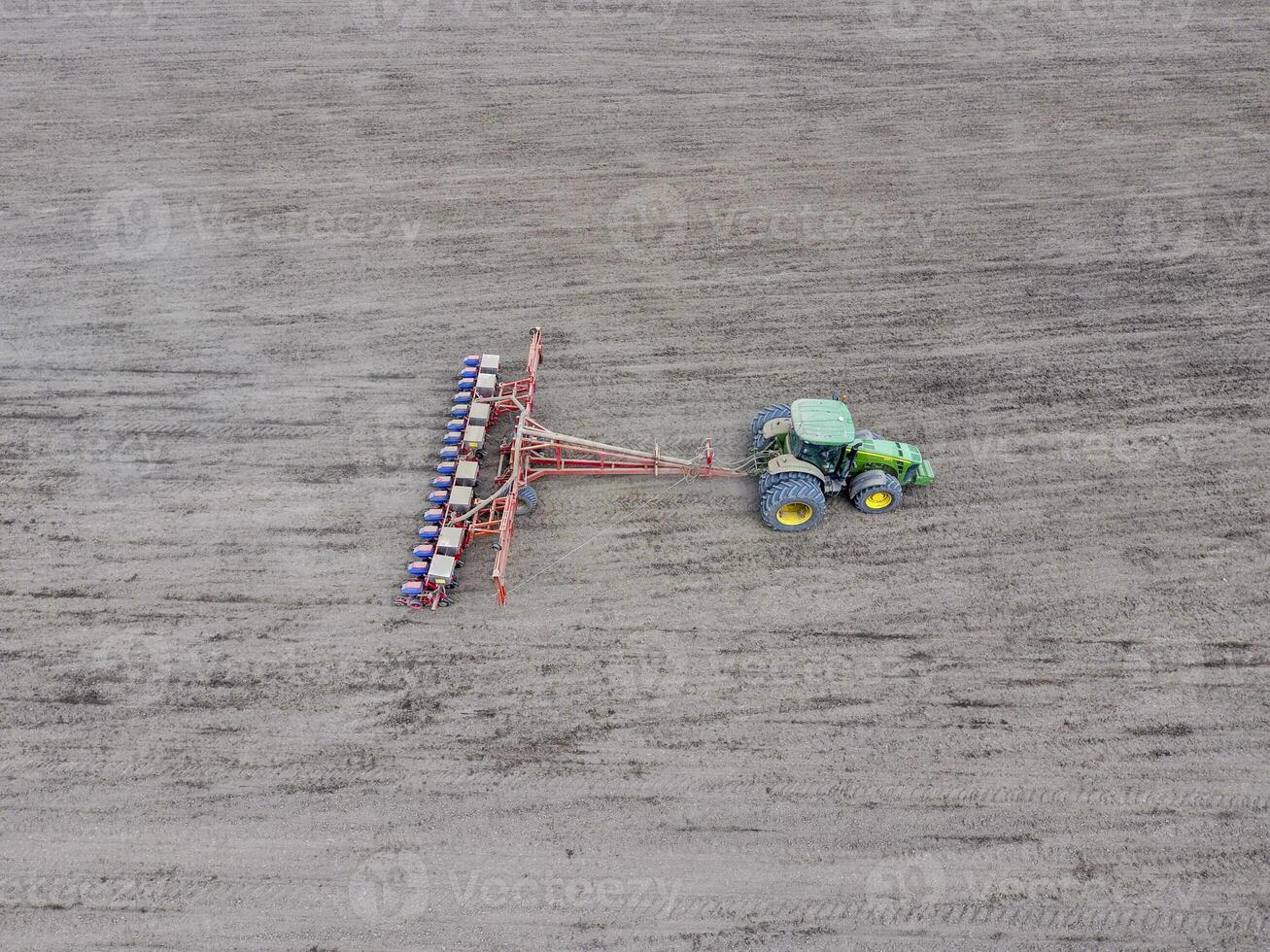 Sowing of corn. Tractor with a seeder on the field. Using a seeder for planting corn. photo