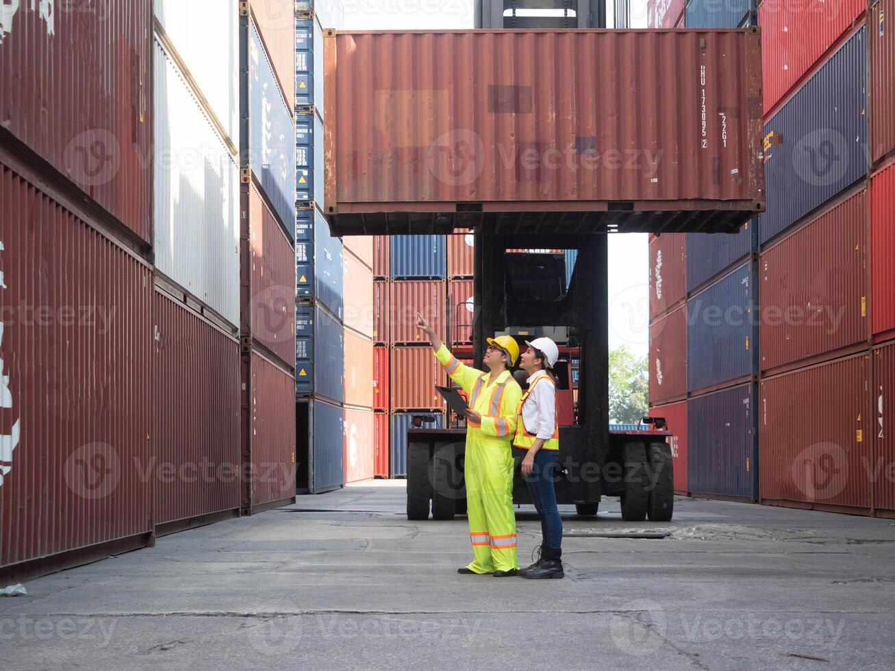 pointing finger cheerful labor employment employee manager supervisor yellow white hardhat helmet safety engineer checklist check up factory forklift carne import export freight professional trade war photo