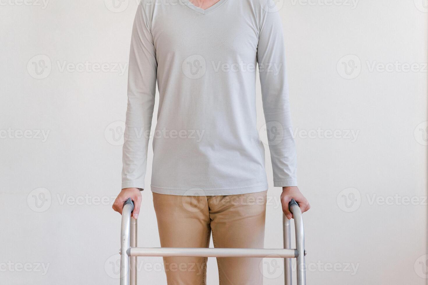 Cropped view of elderly man walking with frame at home, closeup. young male asian using medical equipment to move around his house. Disabled older person in need of professional help photo