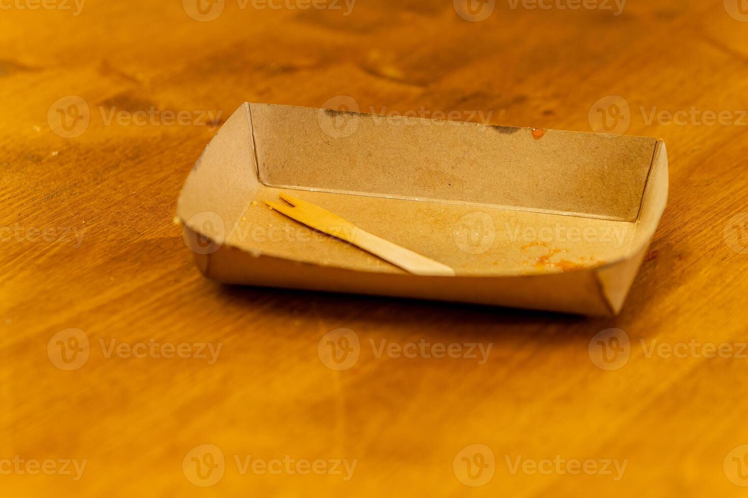 an empty cardboard bowl with a wooden fork photo