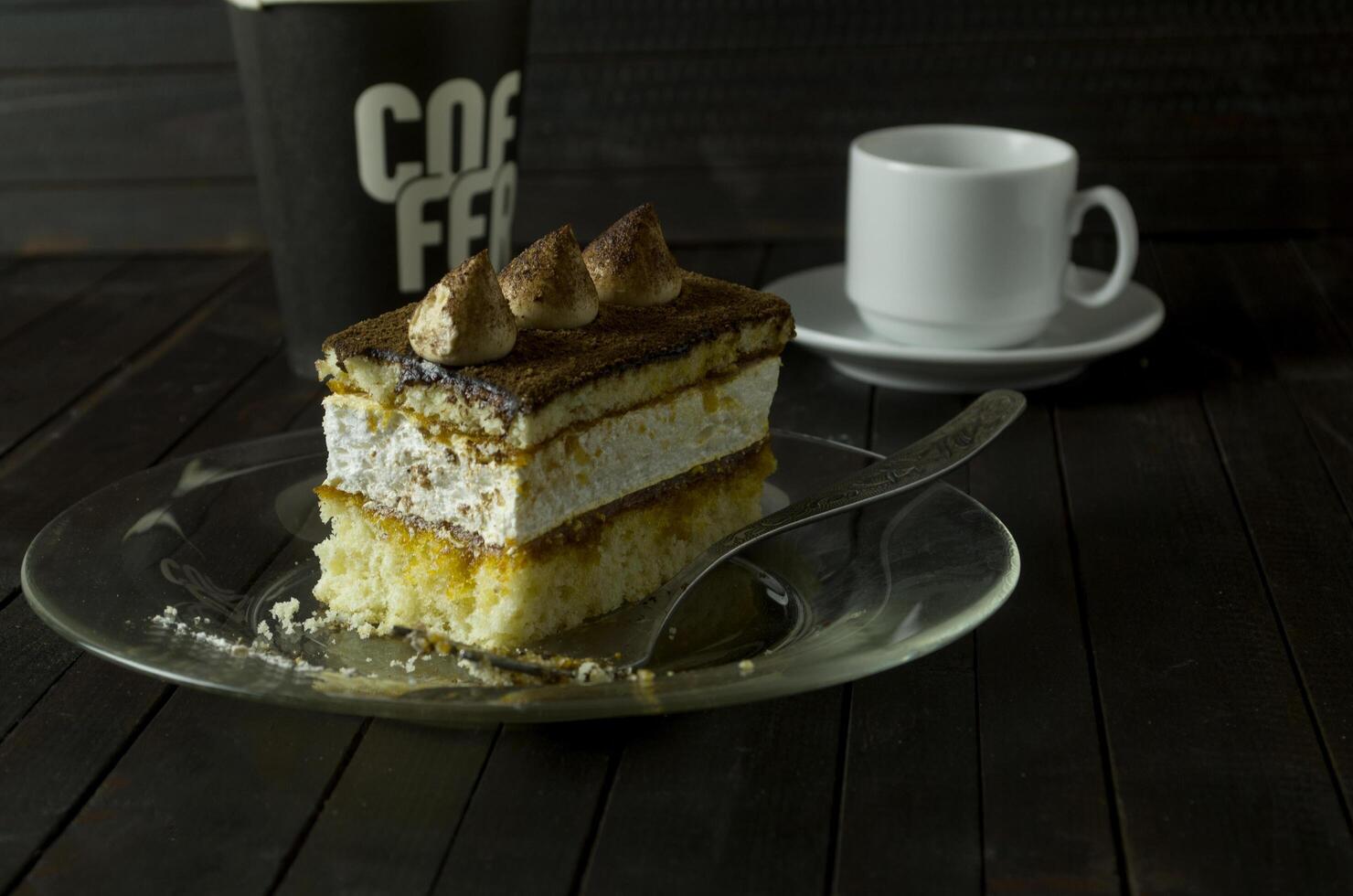 a piece of Truffle cake on glass plate on dark wooden table. photo