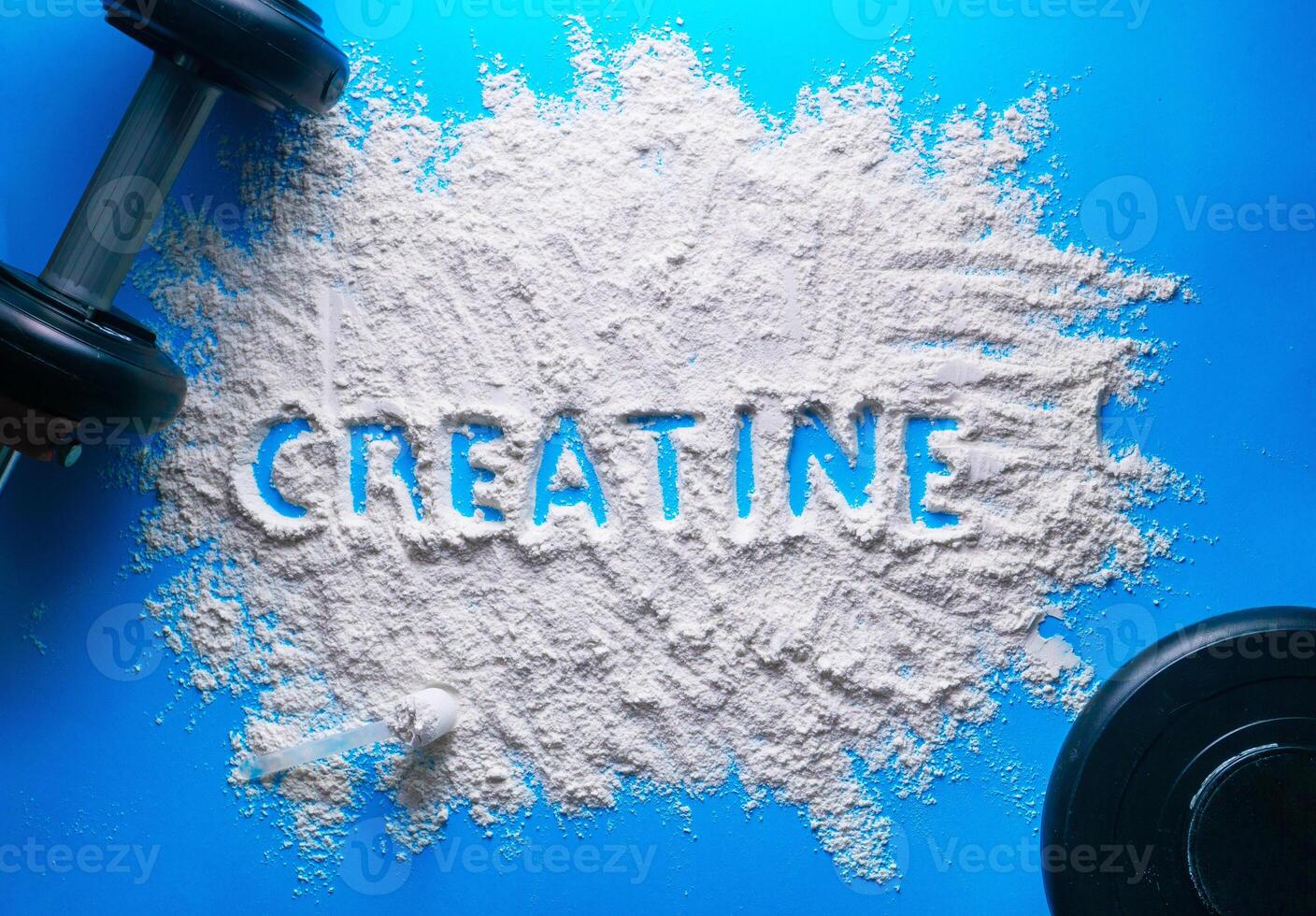 Scattered powder with the word creatine written on it on a blue background. photo