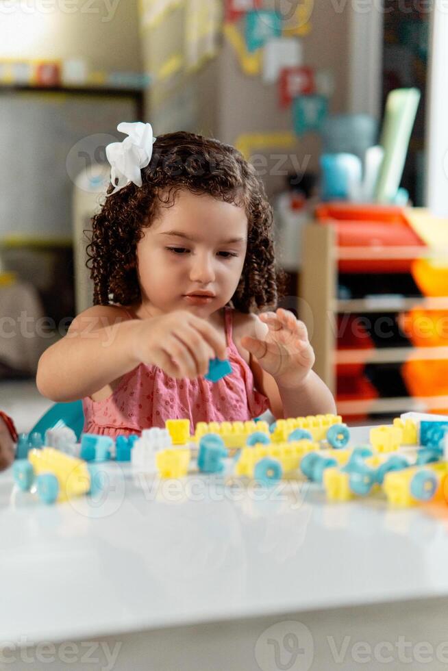 portrait of latin american little child playing with colored block photo