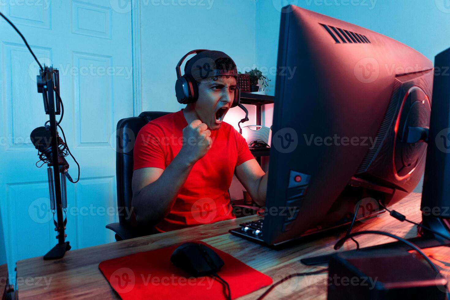 Euphoric young Latin American streamer celebrating a victory. Online gamer and video games concept. photo