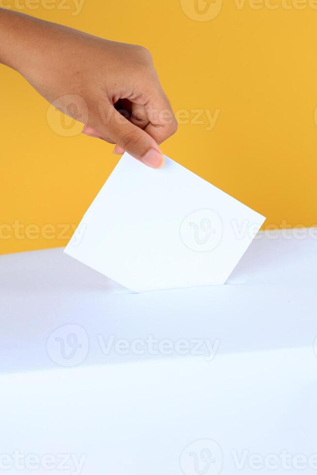 Female Hand Inserting Card Surat Suara to the Box Kotak. photo