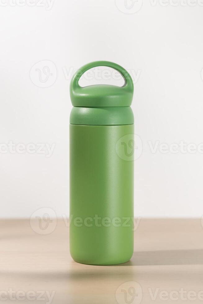 Green tumbler on a wooden table. photo