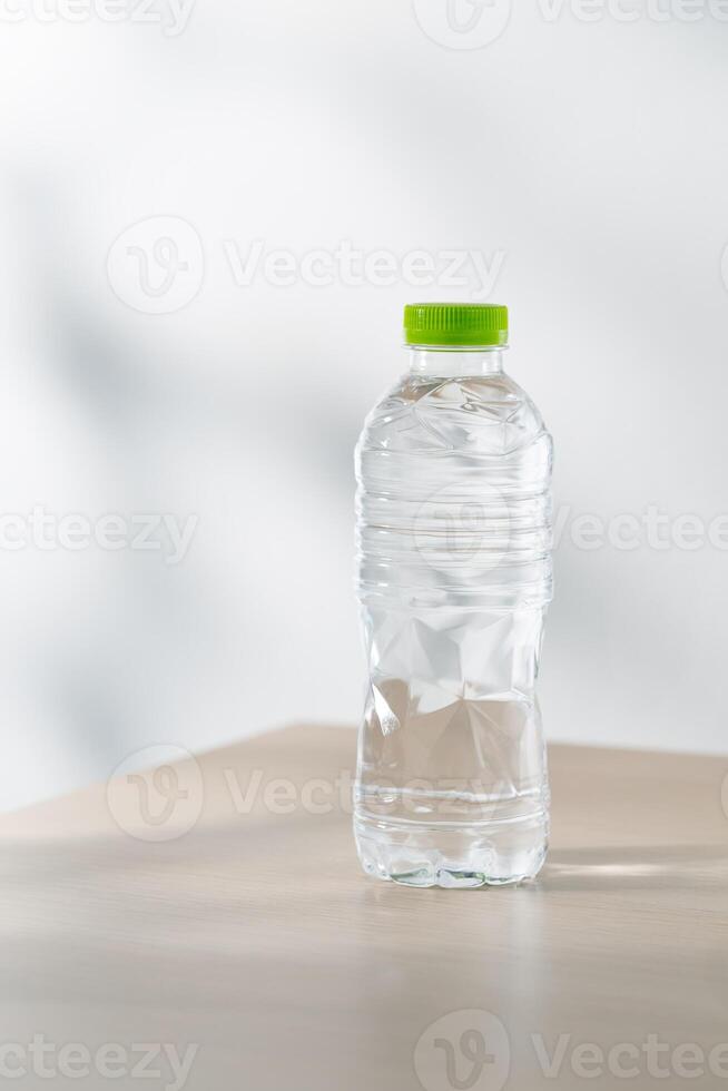 Drinking water in plastic bottles on a wooden table under the morning sunlight. photo