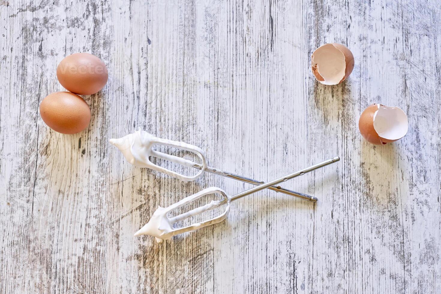 eggs and a whisk on a wooden table photo