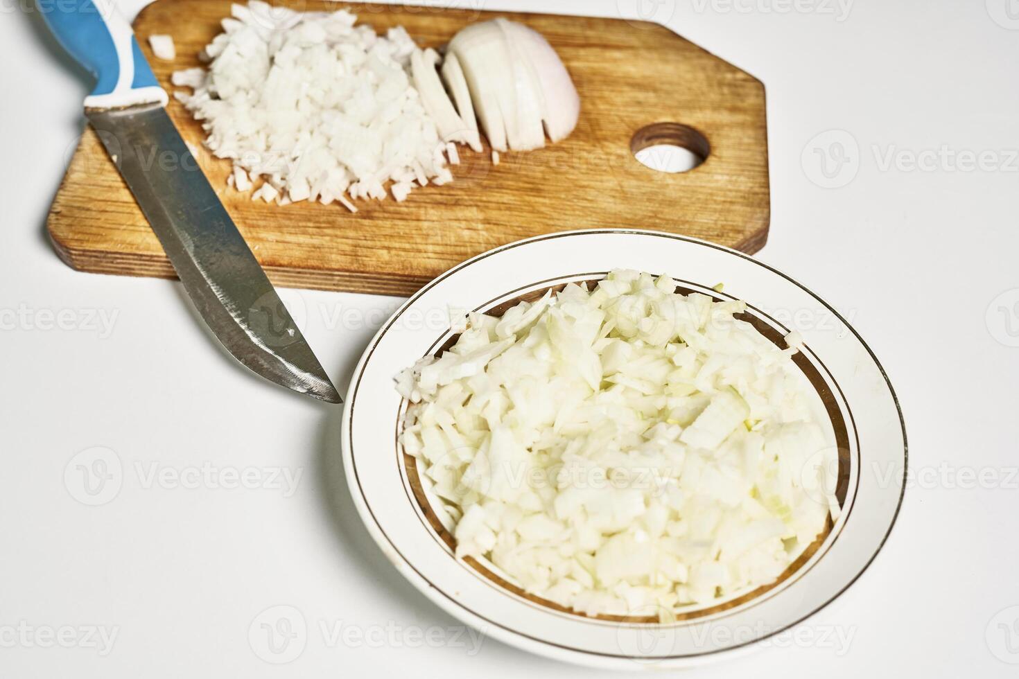 a bowl of onions and a knife on a cutting board photo