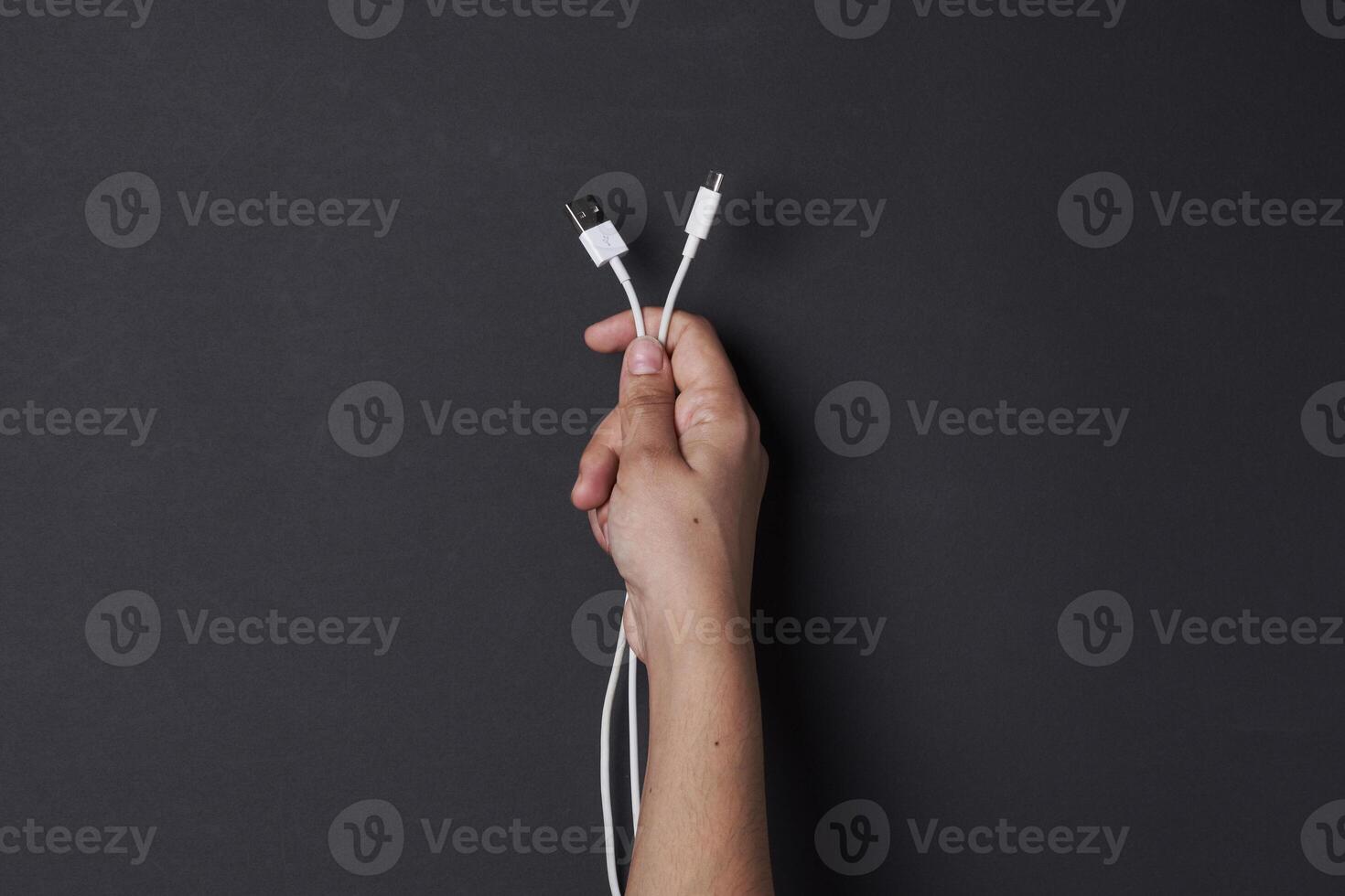 un persona participación un blanco cable con un negro antecedentes foto