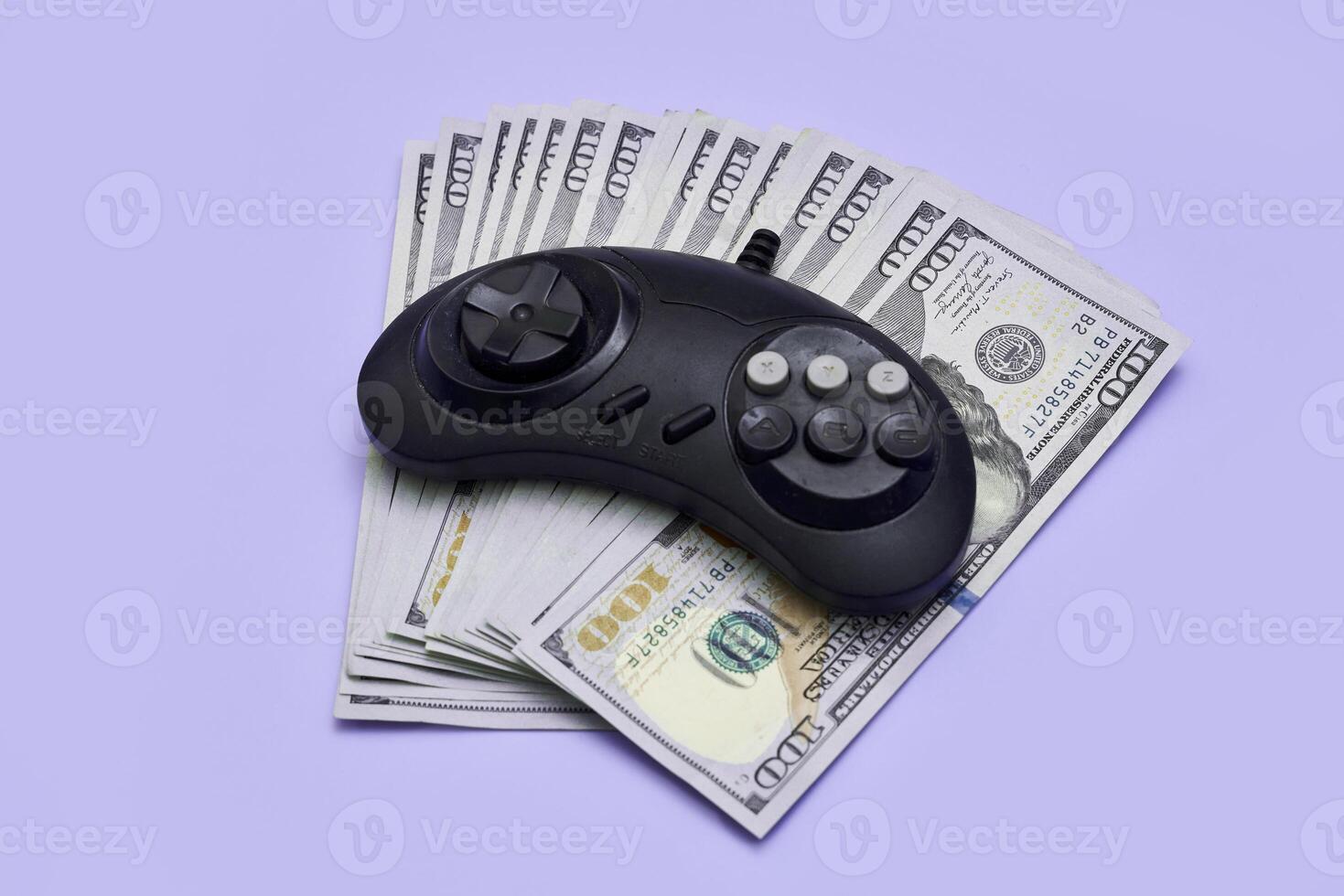 a video game controller and money on a blue background photo