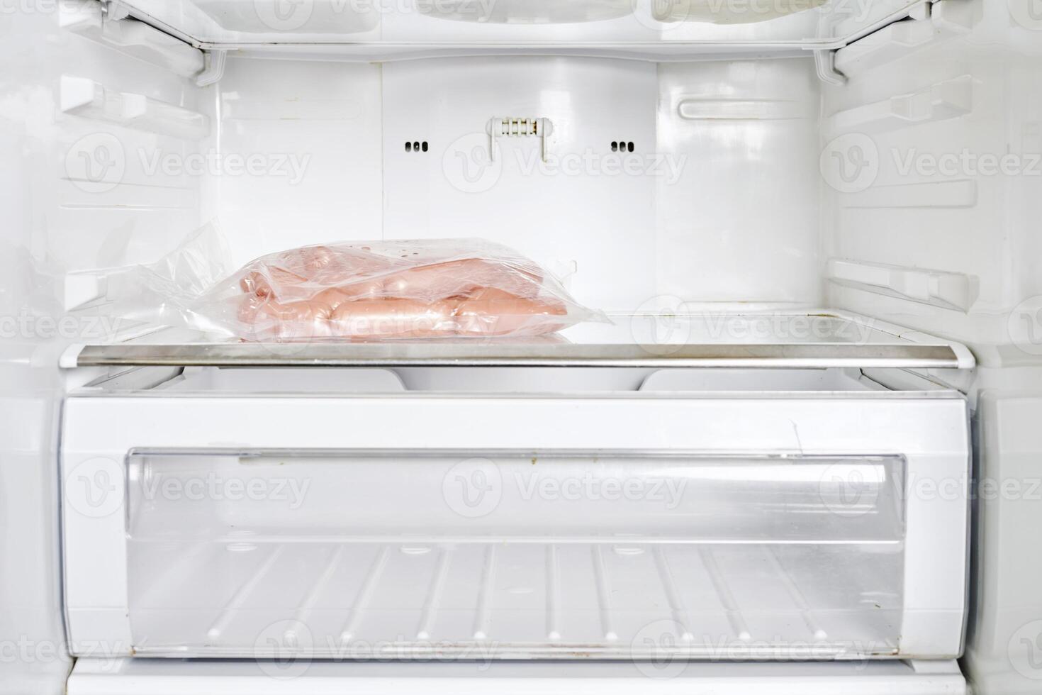 a white refrigerator with a bag of sausage photo