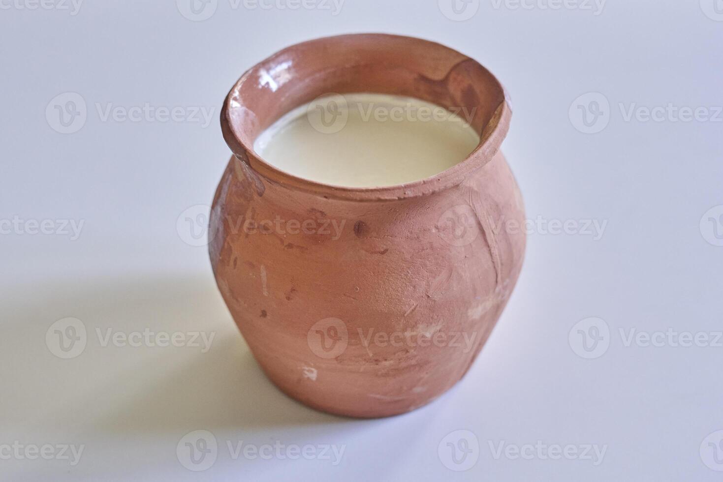 a brown clay jug with milk in it photo