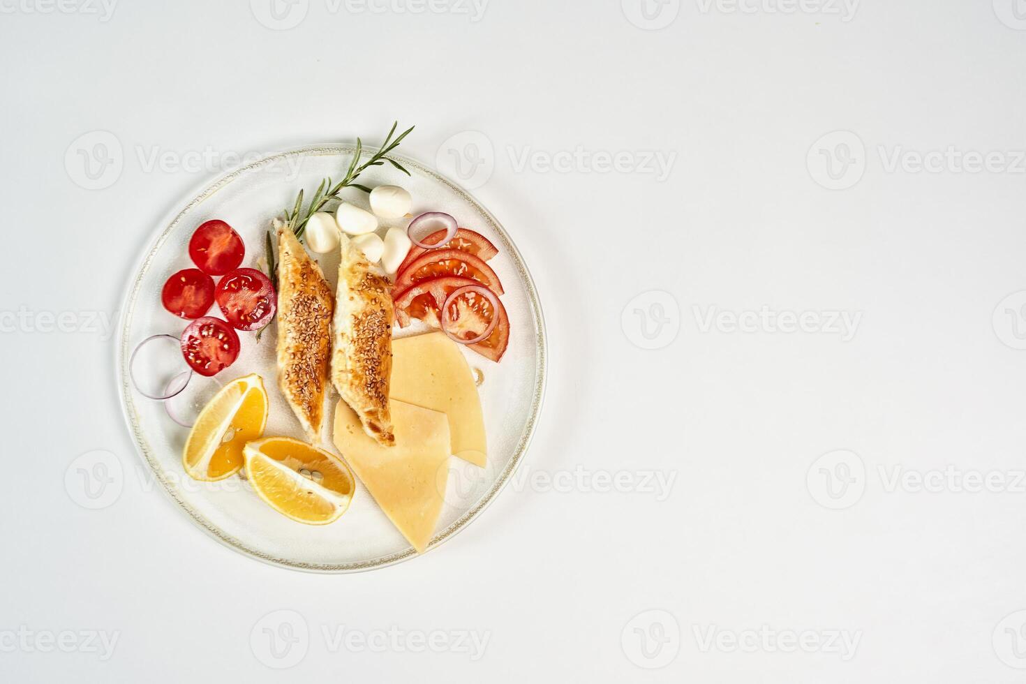 un plato de comida con queso, Tomates, y limón rebanadas foto