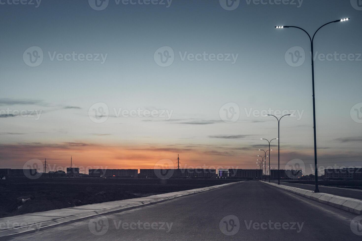 a view of a city street at dusk with traffic photo