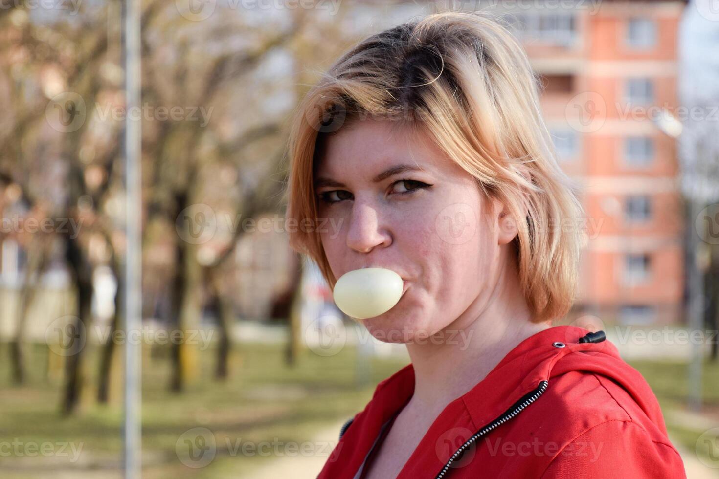 Young blonde woman puffed up bubble of chewing gum. photo