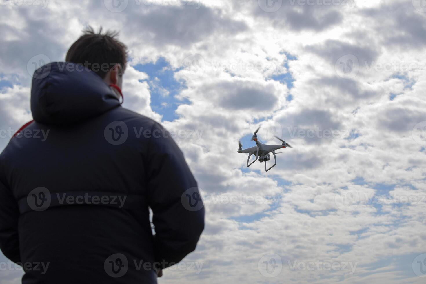 A man with a remote control in his hands. Controlling the flight photo