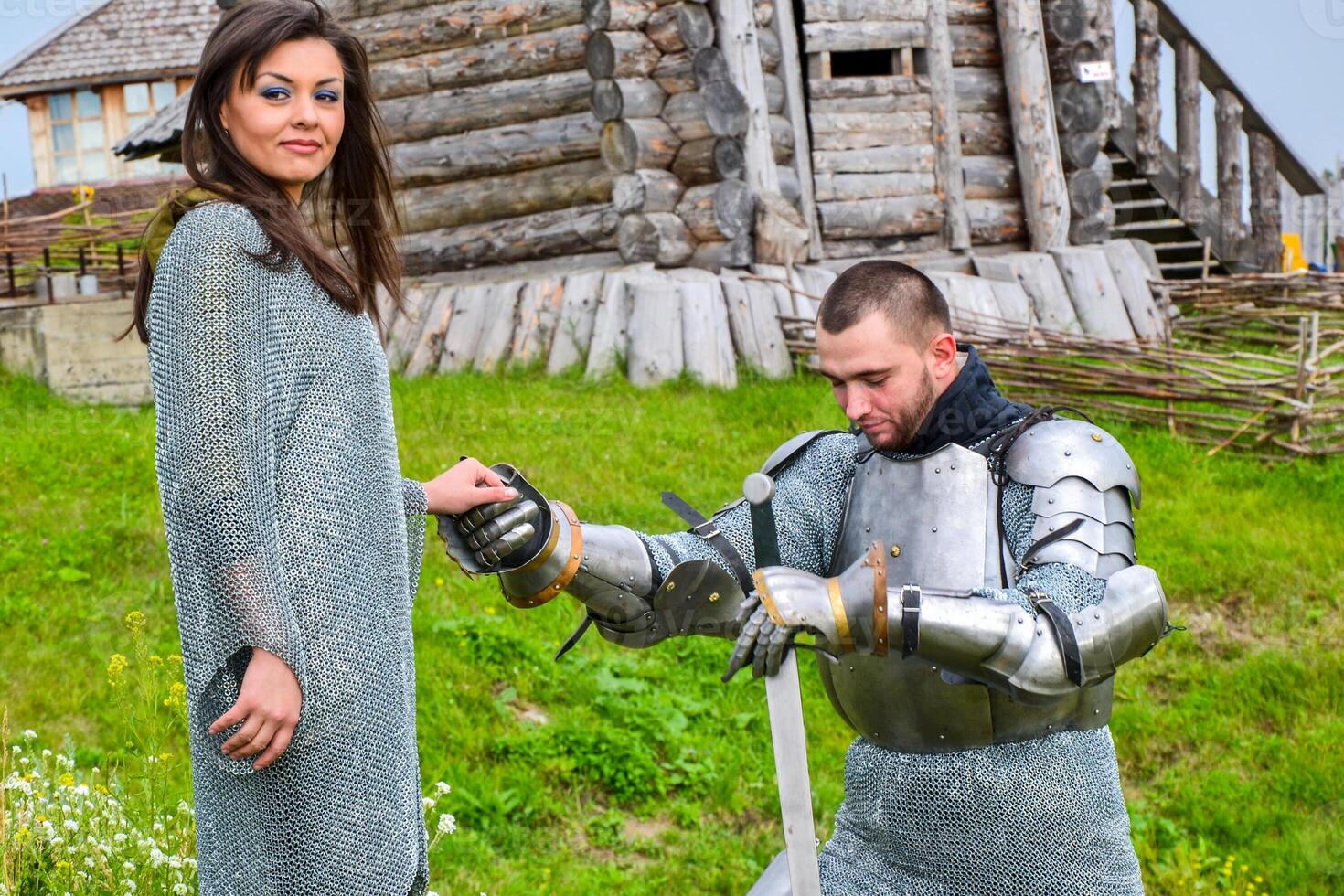 A knight in armor knelt before his lady heart. photo