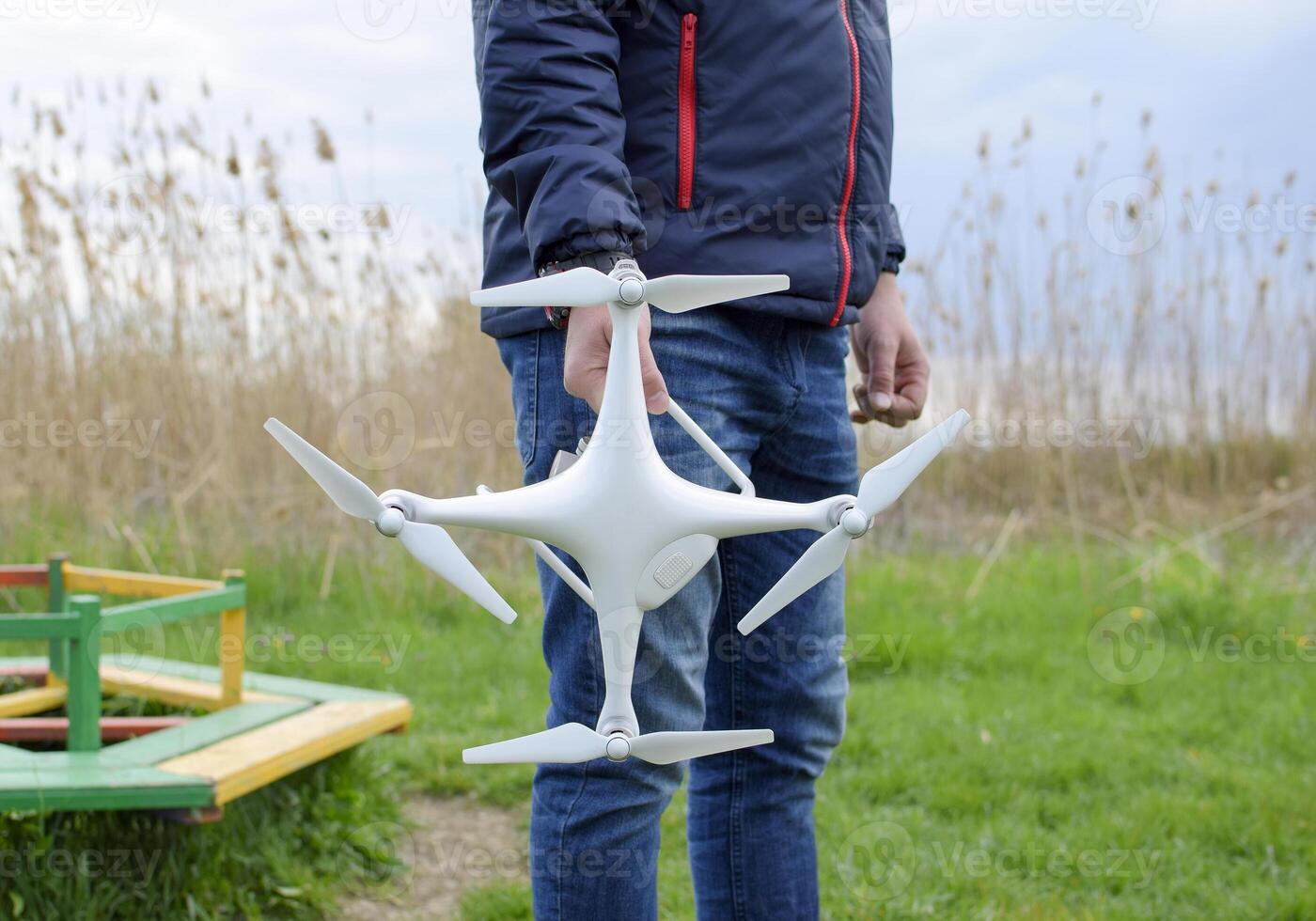 A man with a quadrocopter in his hands. A white drone is being p photo