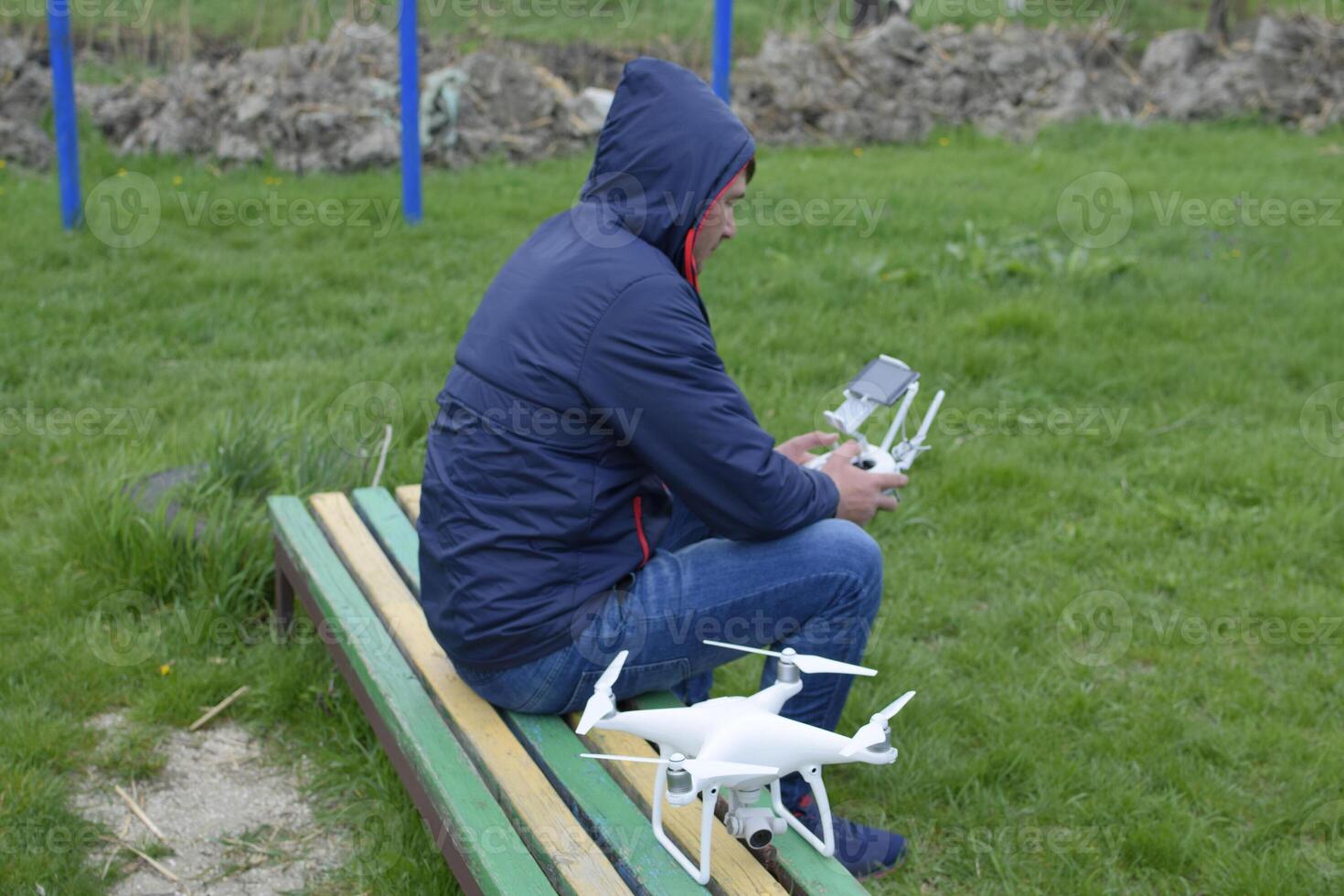 A man with a remote control quadroopter in his hands is sitting photo