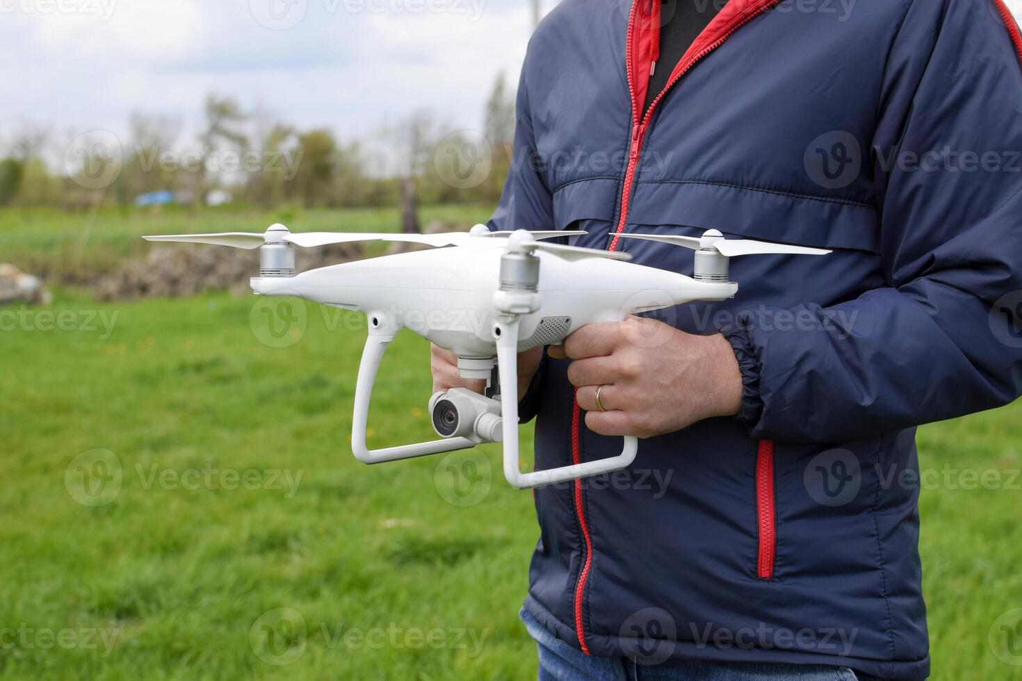 A man with a quadrocopter in his hands. A white drone is being p photo