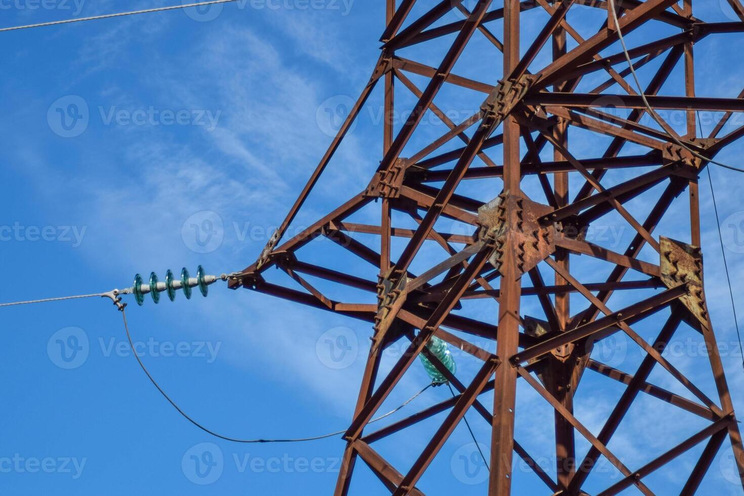 Supports high-voltage power lines against the blue sky with clouds. Electrical industry photo