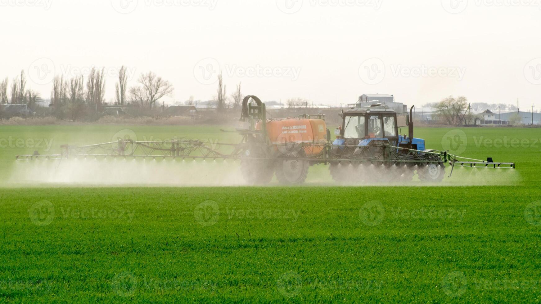 Tractor with a spray device for finely dispersed fertilizer. photo