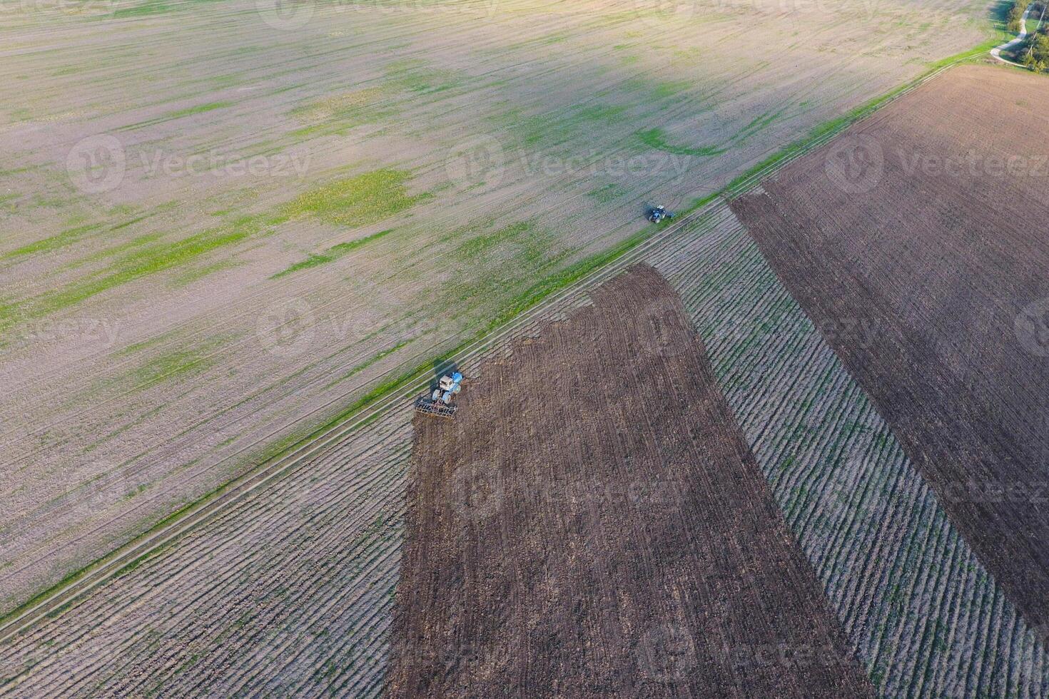 Top view of the tractor that plows the field. disking the soil. Soil cultivation after harvest photo
