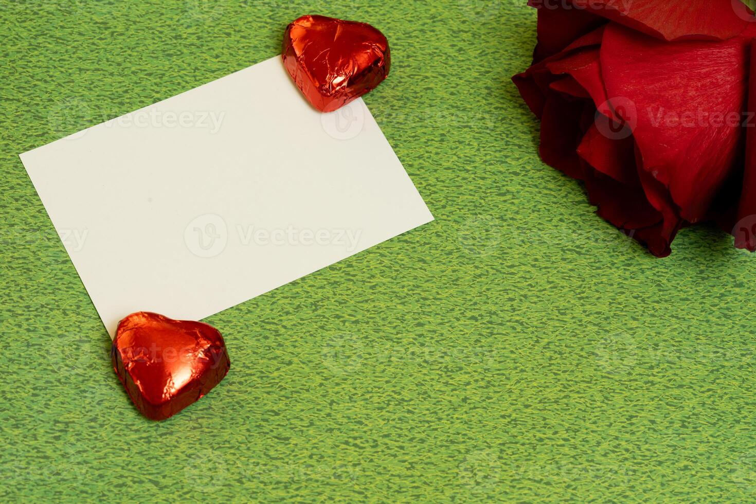 rose chocolates and card valentines day on green background photo