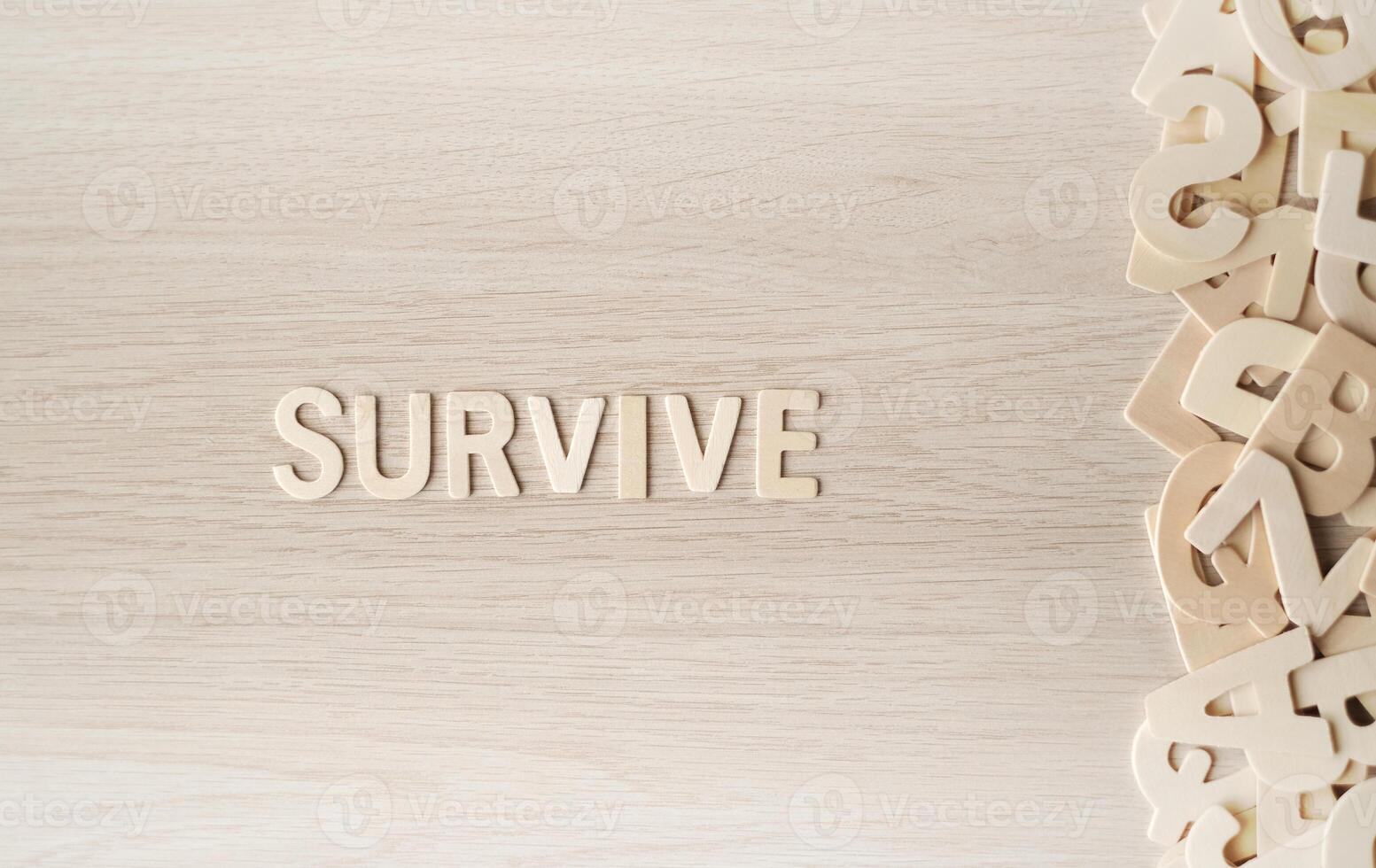 The word SURVIVE, Wooden letters on a wooden table. photo