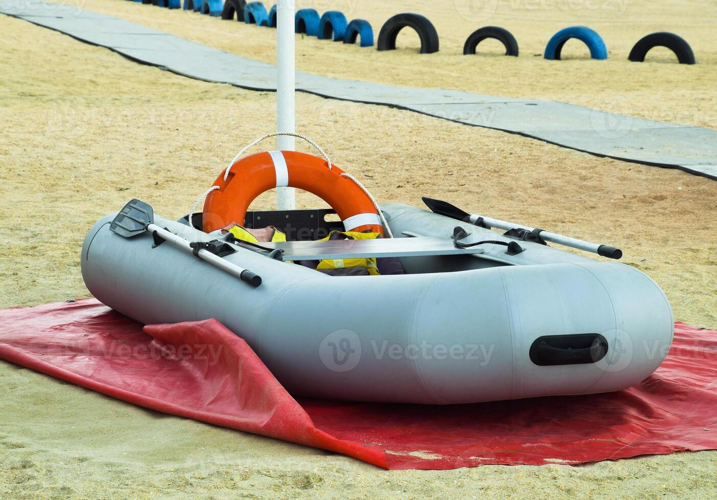 Inflatable Rescue Boat. Gray inflatable boat on the beach in the sand photo