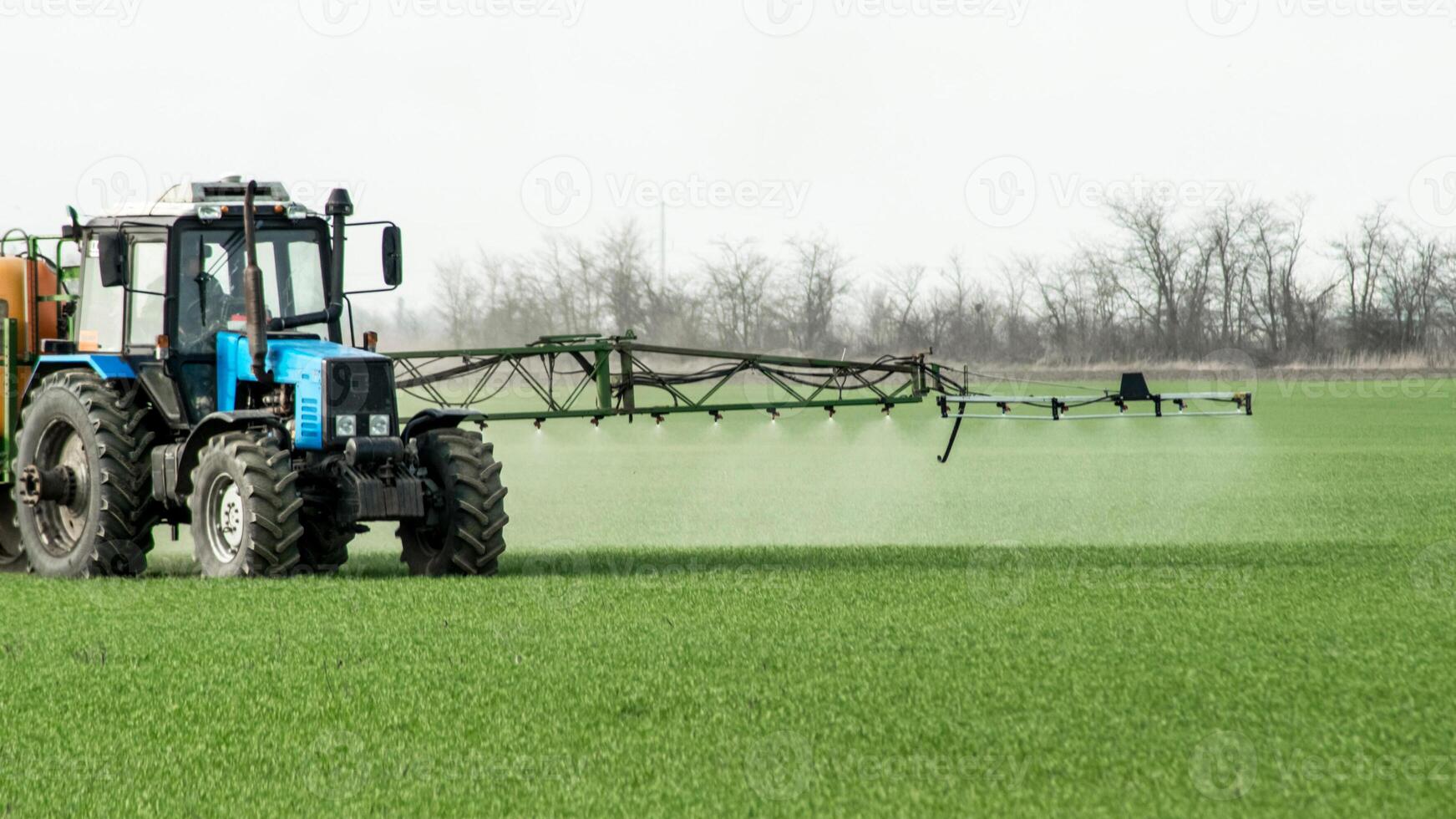 Tractor with a spray device for finely dispersed fertilizer. photo