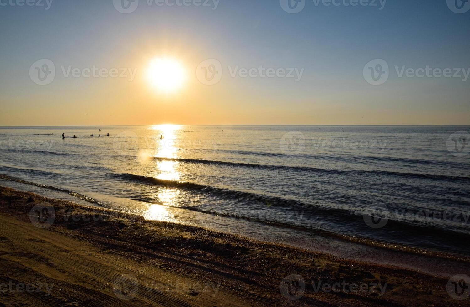 Sea sunset. People bathe in the evening at sunset in the sea. photo