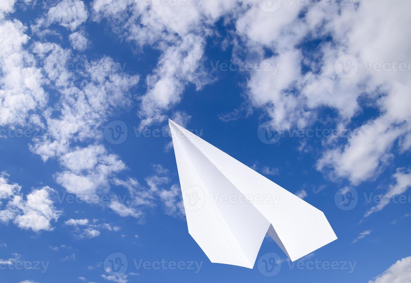 blanco papel avión en un azul cielo con nubes el mensaje símbolo en el Mensajero foto