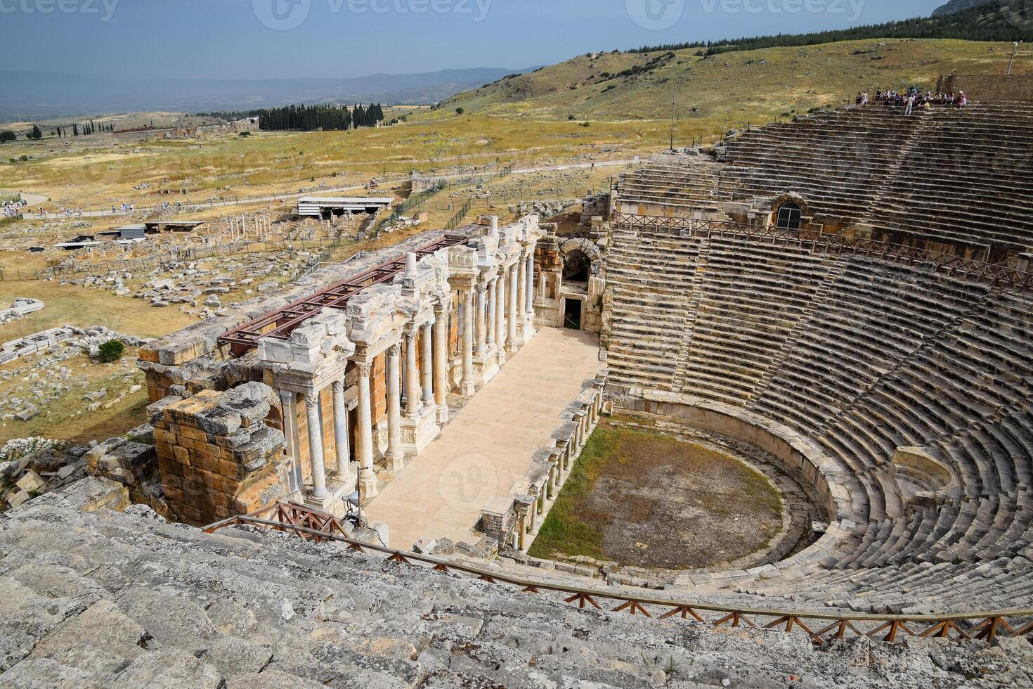 Ancient antique amphitheater in city of Hierapolis in Turkey. Steps and antique statues with columns in the amphitheater photo
